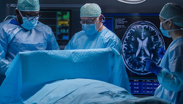 A surgical team of three doctors performing surgery.