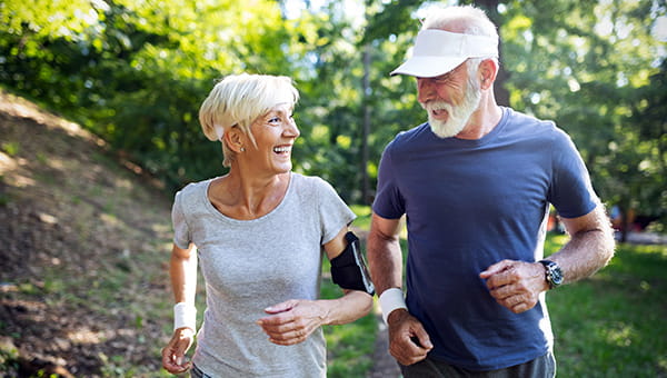 Senior couple running in a park.