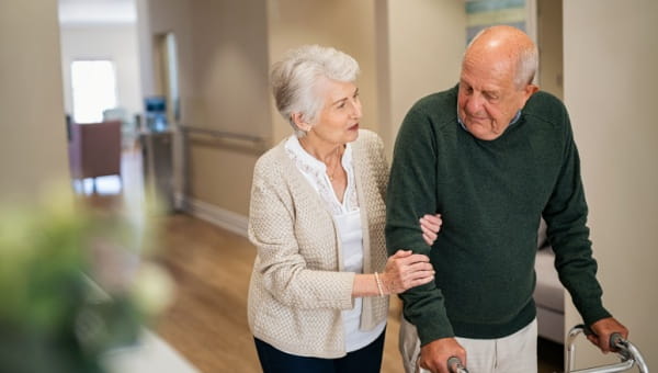 Elderly couple walking together in a hallway at BayCare same day surgery orthopedics facility.