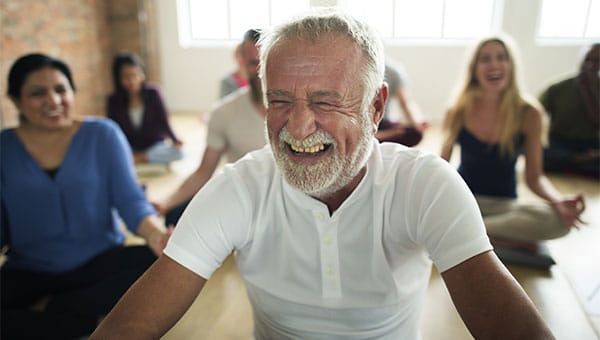 Man in yoga class laughing