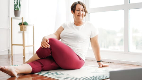 a woman sitting on the floor doing stretches