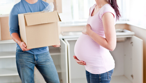 man with box and pregnant woman in pink shirt