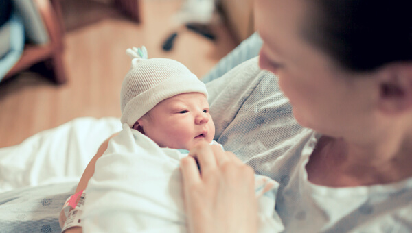 a woman comforting her newborn child