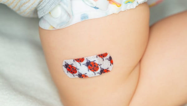 Colorful patch on the thigh of a young child after vaccine injection